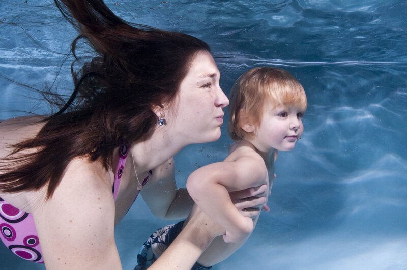 Woman Holding Child Underwater