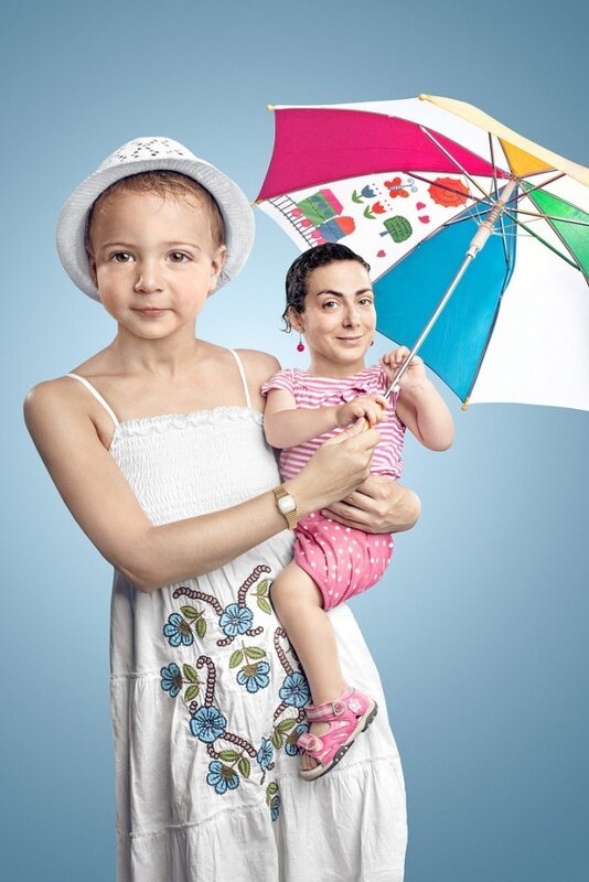woman holding child with umbrella