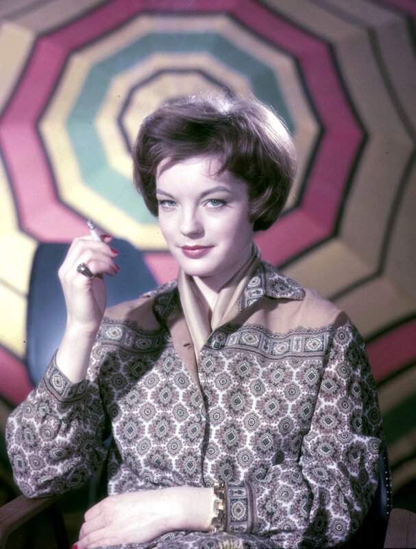 woman holding cigarette in patterned shirt