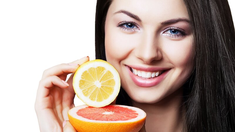 woman holding citrus fruits