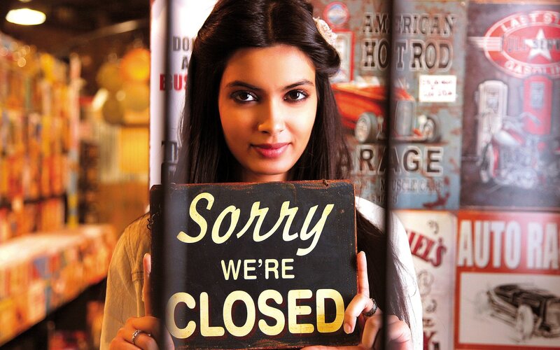 Woman holding closed sign