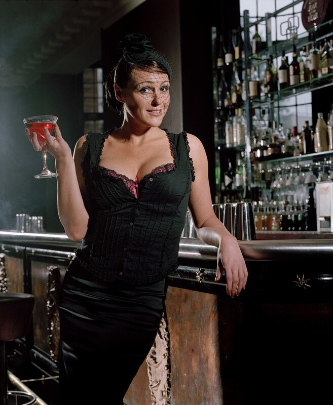 woman holding cocktail at bar