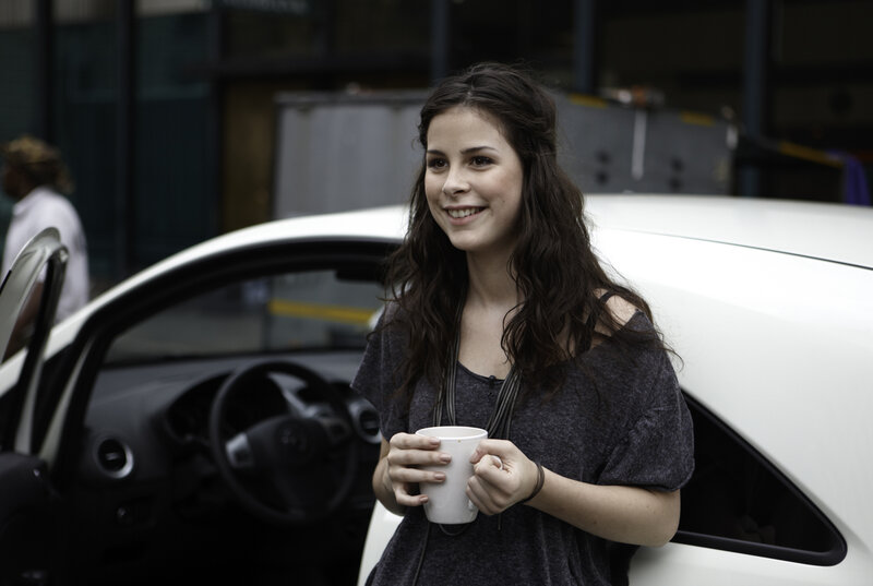 Woman holding coffee cup by car