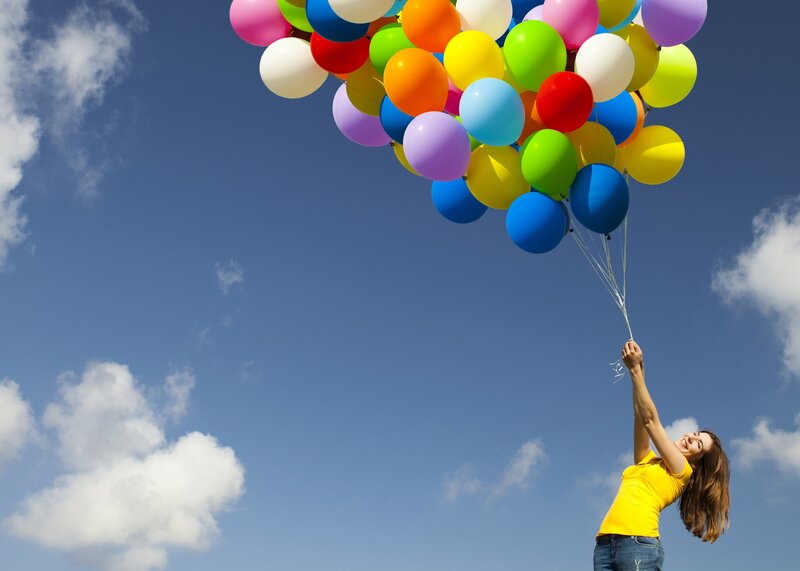 woman holding colorful balloons