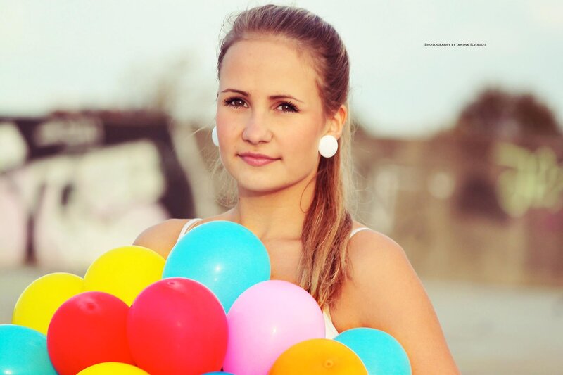woman holding colorful balloons