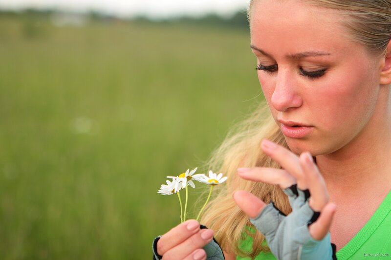 woman holding daisies in field