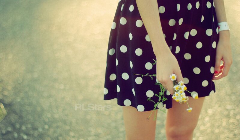 woman holding daisies in polka dot dress