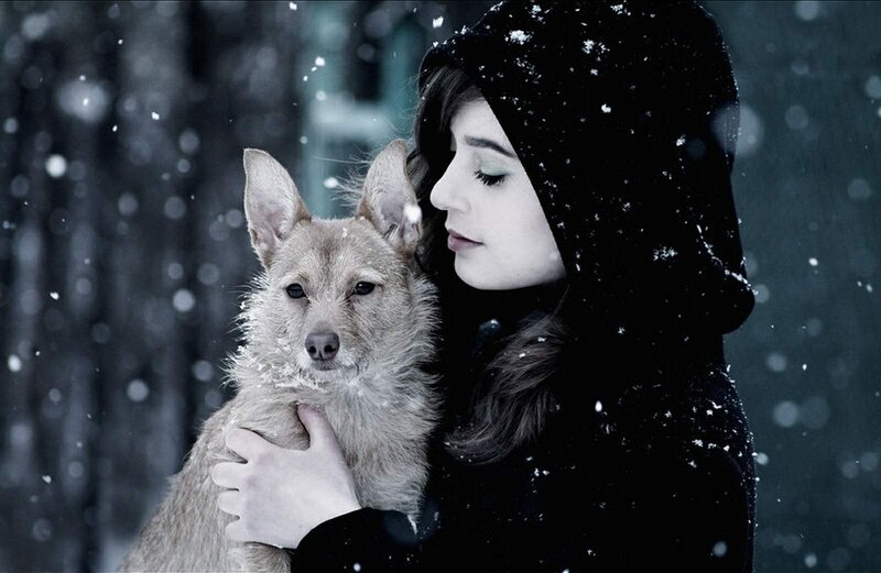 woman holding dog in snow