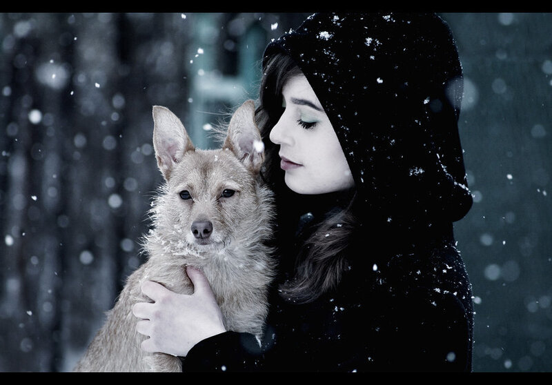woman holding dog in snow