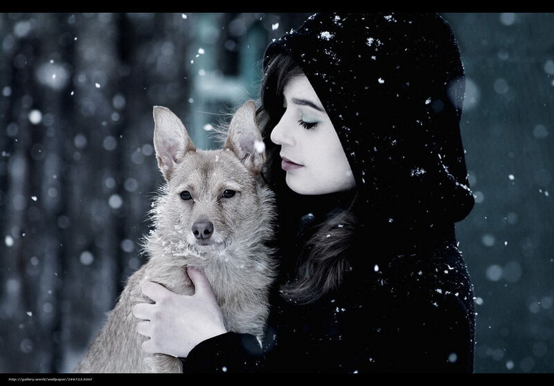 woman holding dog in snow