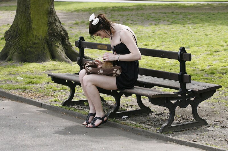Woman Holding Dog on Bench