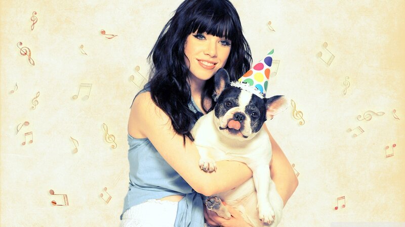 woman holding dog with party hat