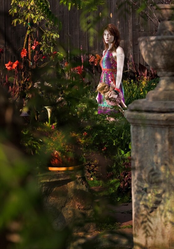 Woman holding doll in garden
