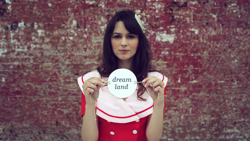 woman holding dream land sign