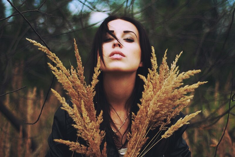 woman holding dried grass in forest