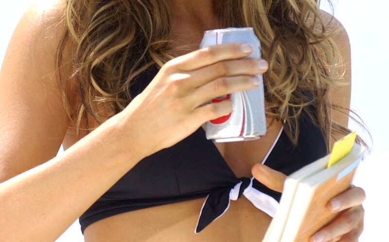 woman holding drink and book