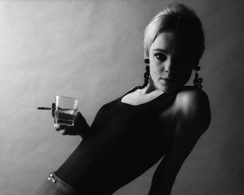 woman holding drink and cigarette