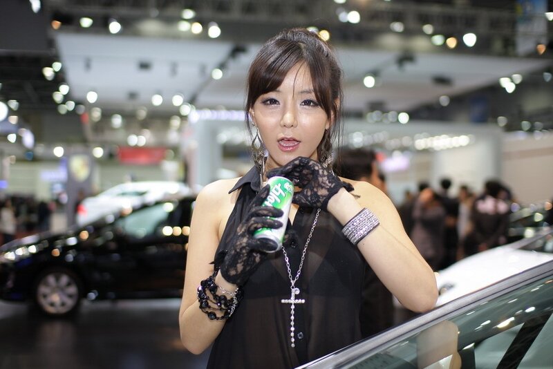 Woman holding drink at auto show