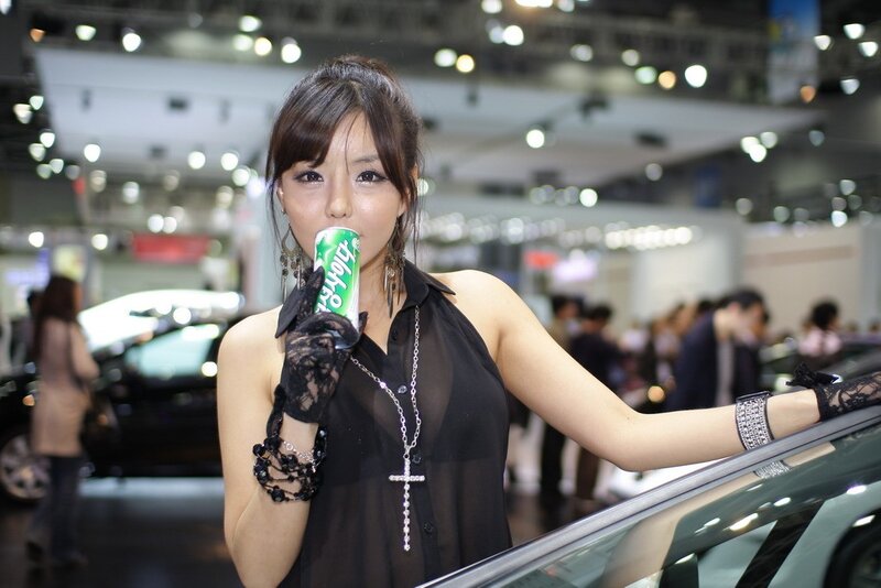 Woman holding drink at auto show
