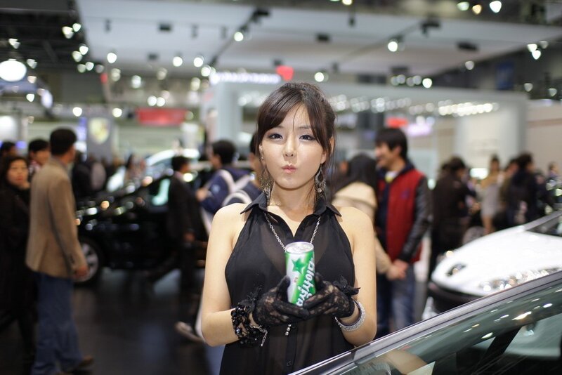Woman holding drink at auto show