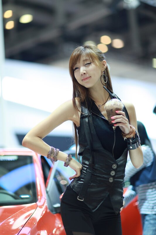Woman holding drink at car show