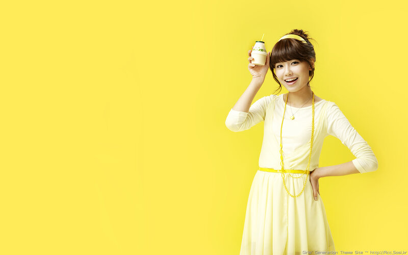 woman holding drink on yellow