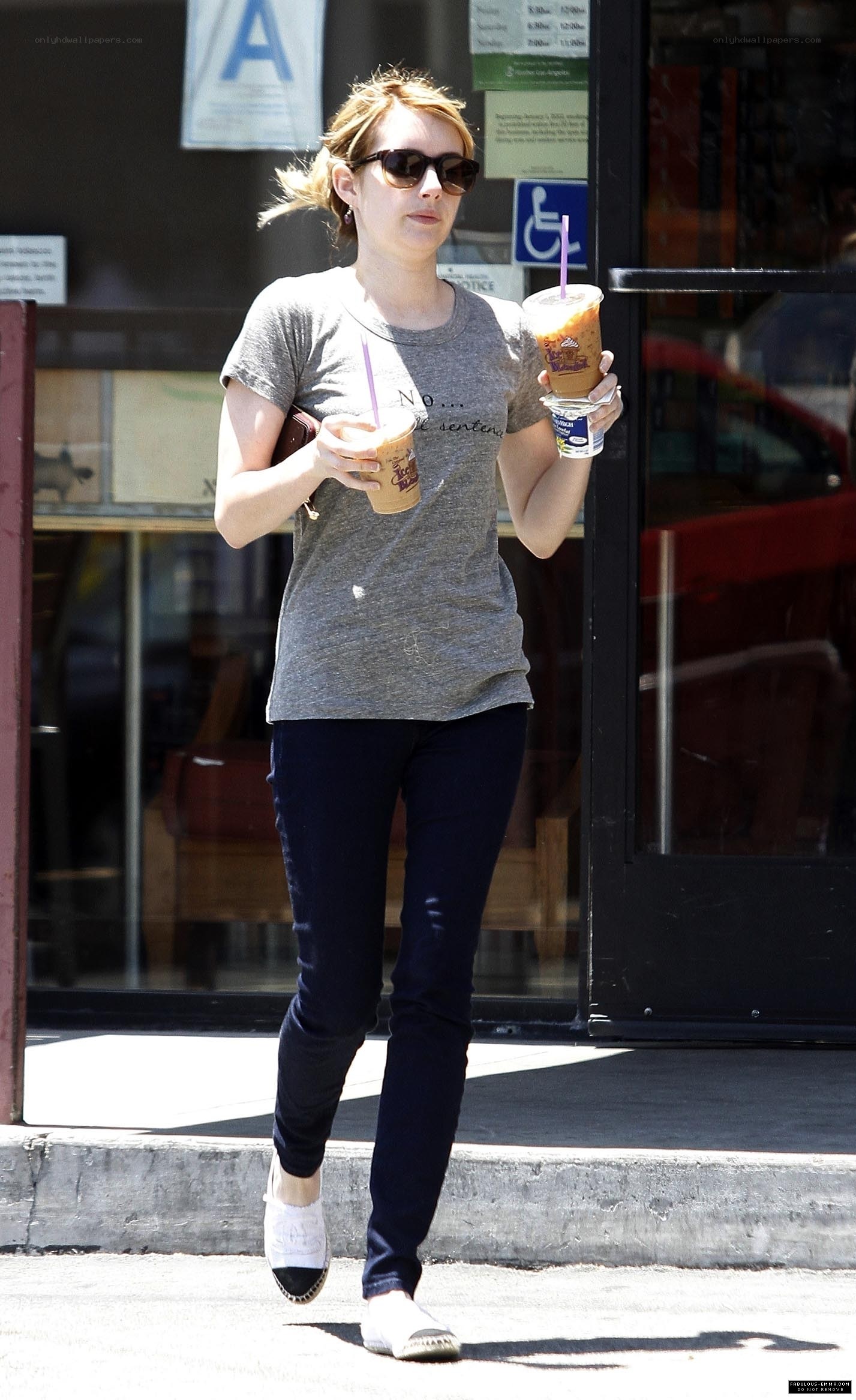 woman holding drinks outside