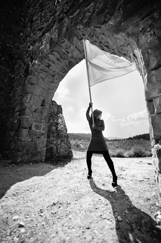 Woman holding flag in stone arch