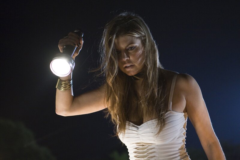 Woman holding flashlight at night