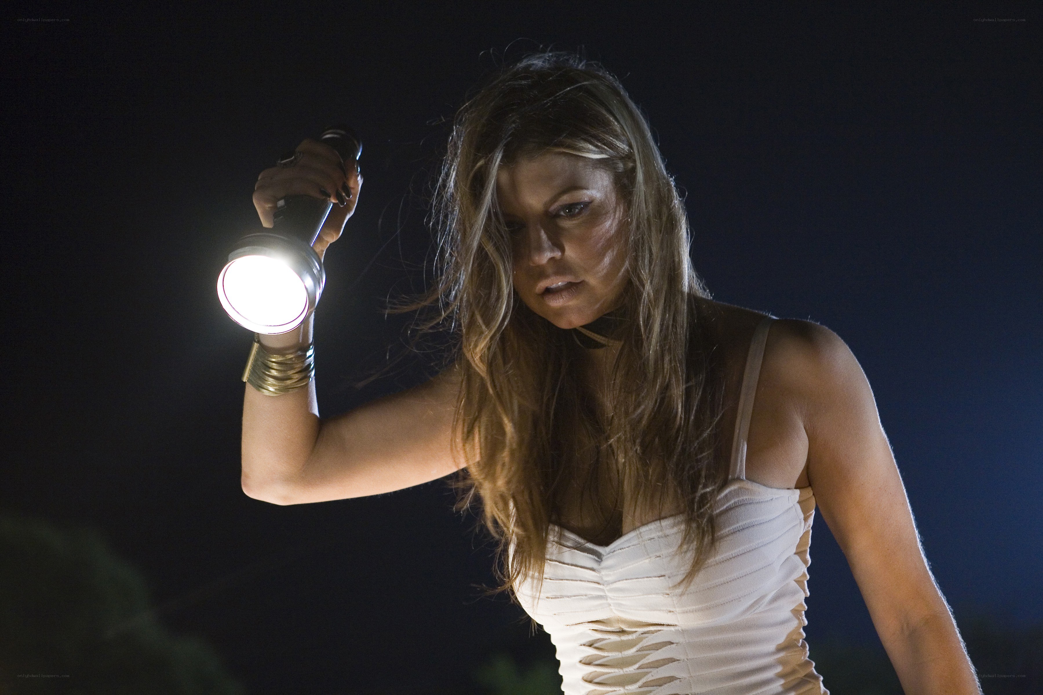Woman holding flashlight at night
