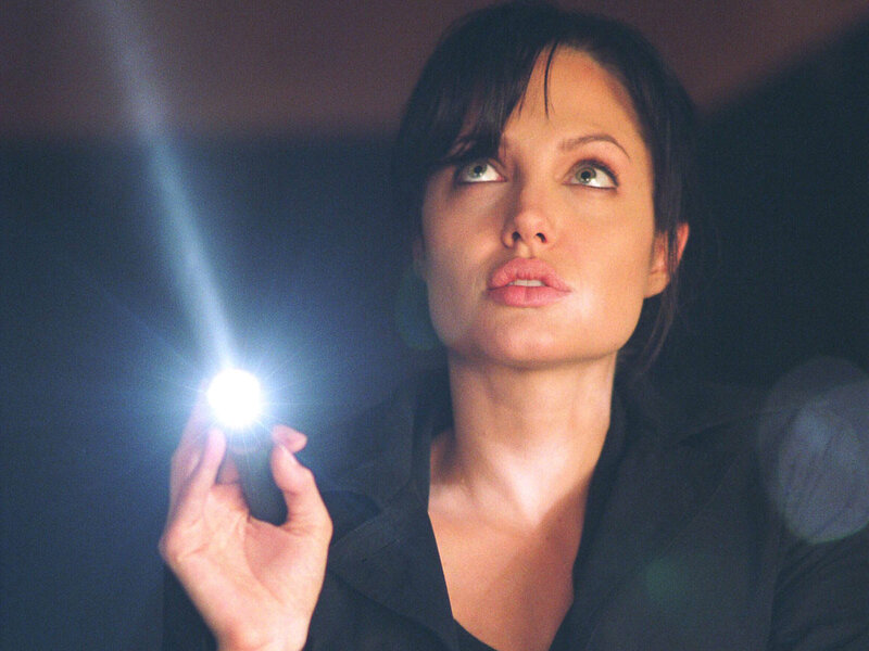 Woman holding flashlight in dark