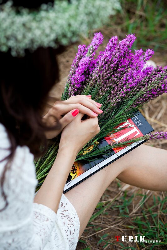 woman holding flowers and book