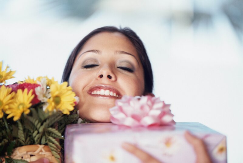 woman holding flowers and gift