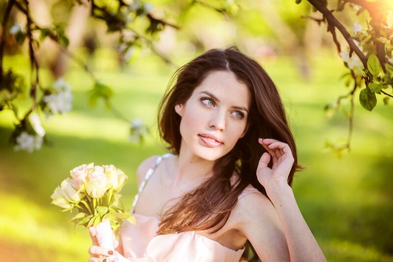 Woman Holding Flowers — Green, Serene, Spring, Photograph, Tree Branches