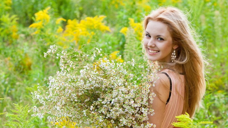 woman holding flowers in field