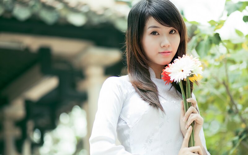 woman holding flowers in traditional dress