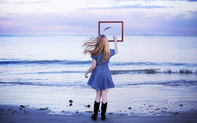 woman holding frame at beach