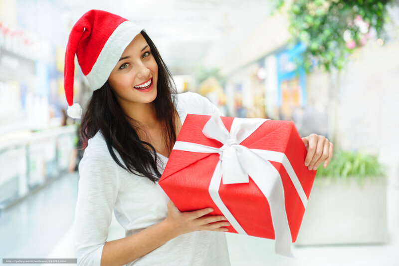 woman holding gift in santa hat