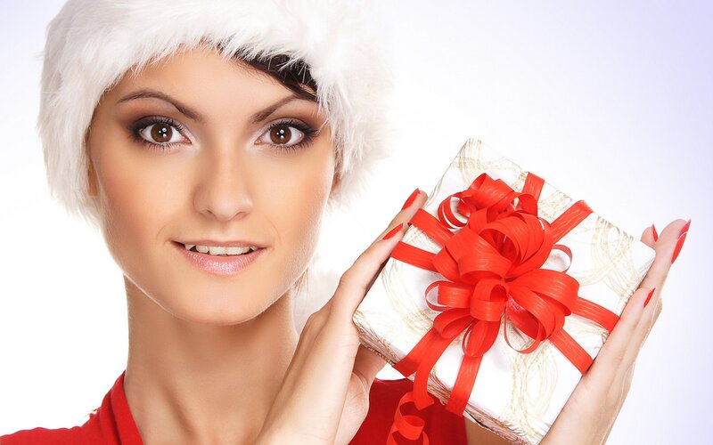 woman holding gift with santa hat