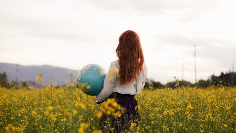 woman holding globe in field