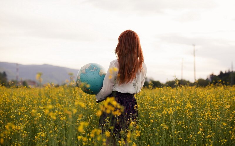 woman holding globe in field