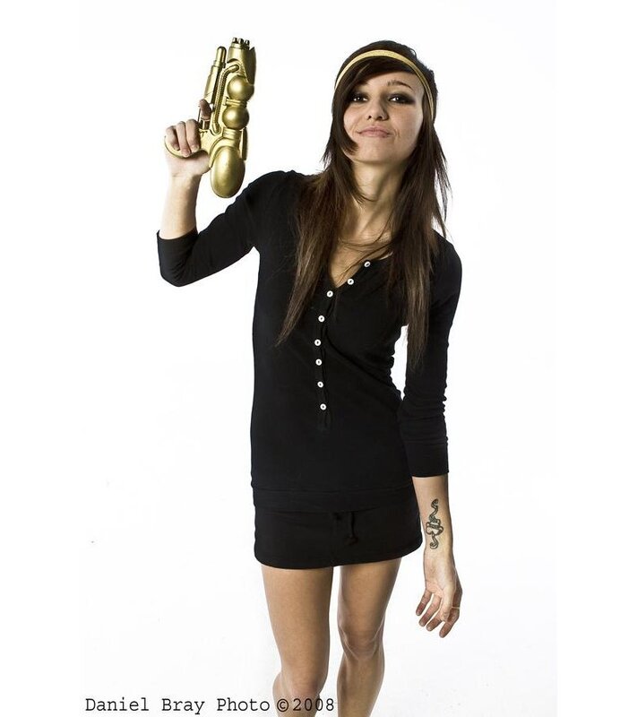 Woman holding golden gun prop