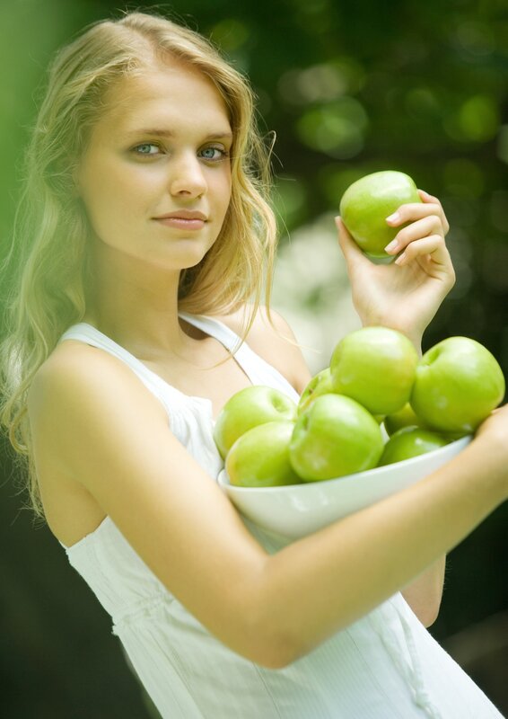 woman holding green apples