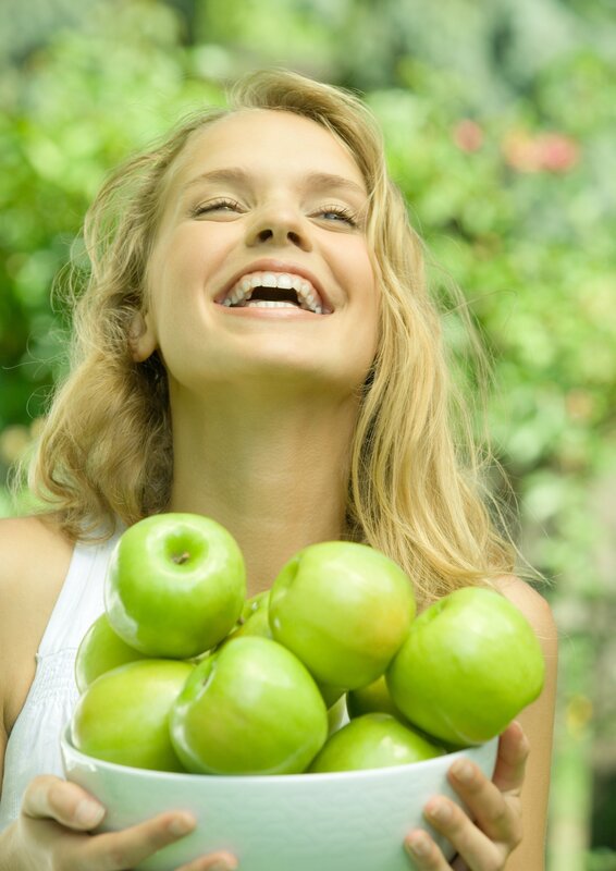 woman holding green apples