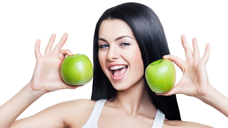 woman holding green apples