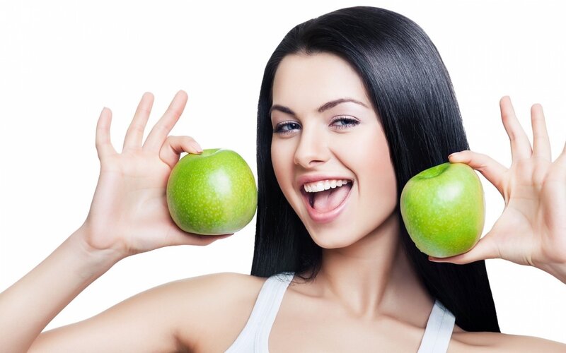 woman holding green apples