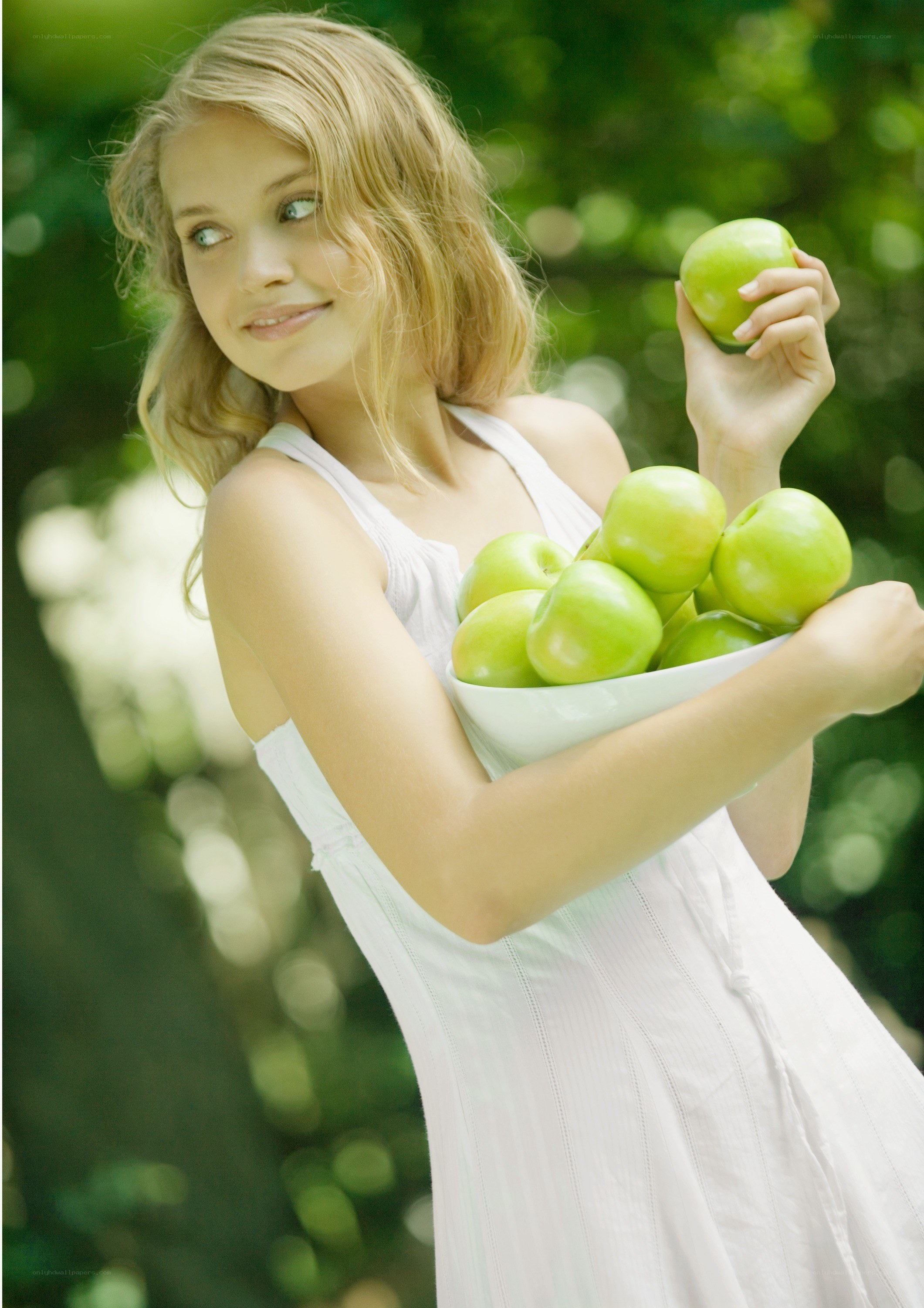 woman holding green apples