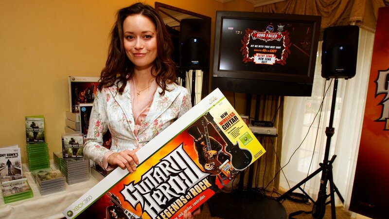 Woman holding Guitar Hero II box