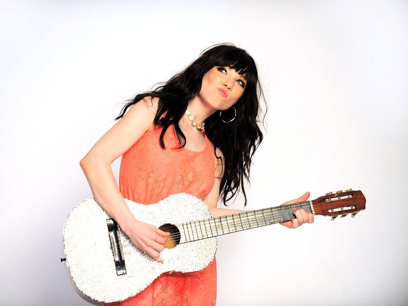 Woman Holding Guitar — White, Playful