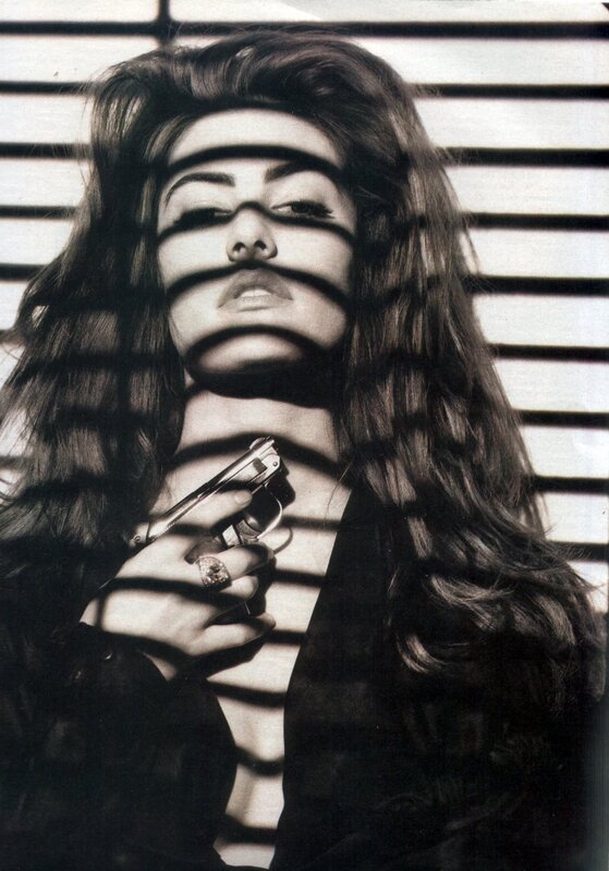woman holding gun behind blinds